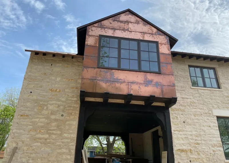 Copper metal panel facade on a stone building for Skylight Installation in Creston